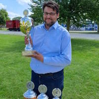 Bild vergrößern:Tobias Krull präsentiert den Wanderpokal für den Wettbewerb Löschangriff Nass der nun bei der Kinder- und Jugendfeuerwehr Ottersleben verbleiben wird. 