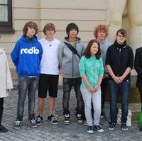 Bild vergrößern:Schüler des Ökum. Domgymnasium mit ihrer Lehrerin Hannah Lange (l.) und der Landesgeschäftsf. der Volksbundes Dt. Kriegsgräberfürsorge Jan Scherschmidt (r.) bei der Übergabe von Steinen für die Gedenkstätte Riga-Bikernieki an einen Vertreter der Landeshauptstadt