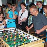 Bild vergrößern:Der Vorsitzende der Fraktion CDU/BfM im Stadtrat Wigbert Schwenke MdL (dunkles Hemd) probiert bei der Eröffnung des Kinder- und Jugendhauses Altstadt gleich das dortige Kickerspiel aus