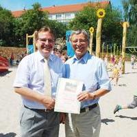 Bild vergrößern:Der Finanzbeigeordnete Klaus Zimmermann übergibt Stadtrat Reinhard Stern eine Urkunde aus Anlass der Übernahme der Spielplatzpatenschaft für den Spielplatz in der Motzstr. durch ihn. (v.l.n.r.)