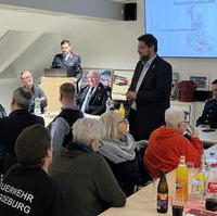 Bild vergrößern:Tobias Krull MdL (stehend) bei seinem Grußwort bei der Freiwilligen Feuerwehr Prester am 10. Februar 2023.