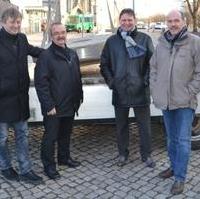 Bild vergrößern:Stadtratsvorsitzender Andreas Schumann, Fraktionsvorsitzender Wigbert Schwenke MdL, Stadtrat Bernd Heyneman und Stadtrat Frank Schuster mit dem Mühlstein kurz vorm abladen desselben (v.l.n.r.). Die Firma Paul Schuster unterstütze die Aktion maßgeblich.
