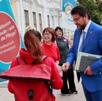 Bild vergrößern:Tobias Krull im Gespräch mit Teilnehmerinnen einer Demo vor dem Landtag am 22. August. 