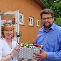 Bild vergrößern:Die Hortleiterin Frau Viehöfer bei der Annahme des Präsents zum Tag der Kinderbetreuung von Tobias Krull MdL