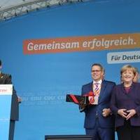 Bild vergrößern:CDU-Kreisvorsitzender Tobias Krull (l.) bei seinem Schlusswort zur sehr gelungenen Veranstaltung mit Bundeskanzlerin Dr. Angela Merkel (2.v.r.). Von Bundestagskandidat Tino Sorge (3.v.r.) gab es als Geschenk noch einen Kuchen vom Kaffeehaus Köhler 