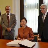 Bild vergrößern:Die Botschafterin des Königreichs Thailand, I.E. Nongnuth Phetcharatana (Mitte) trägt sich im Beisein von Stadtrat Frank Schuster (links) und Bürgermeister Dr. Rüdiger Koch (rechts) in das Goldene Buch der Landeshauptstadt Magdeburg ein. 