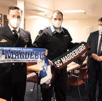 Bild vergrößern:Beim Besuch der Fregatte SACHSEN-ANHALT am 06. Januar übergab Tobias Krull MdL an die Besatzungsmitglieder Fan-Artikel des FCM und SCM: